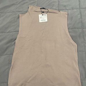 Tan sleeveless top with a sideway collar